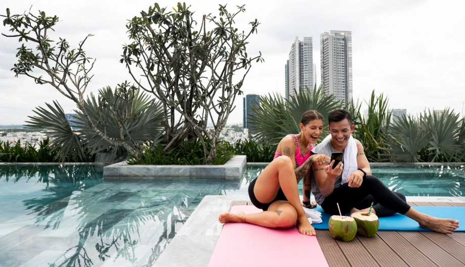 Couple relaxing after yoga by rooftop pool in a wellness luxury home Singapore