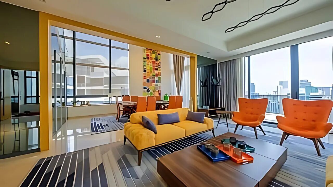 Trilight Penthouse contemporary living area with vibrant yellow and orange seating
