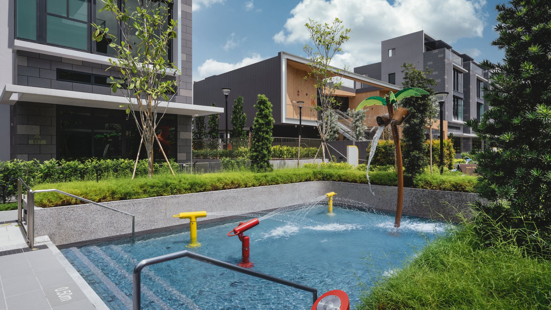 Shallow children's water play pool with water jets and palm-tree water feature at Belgravia Ace