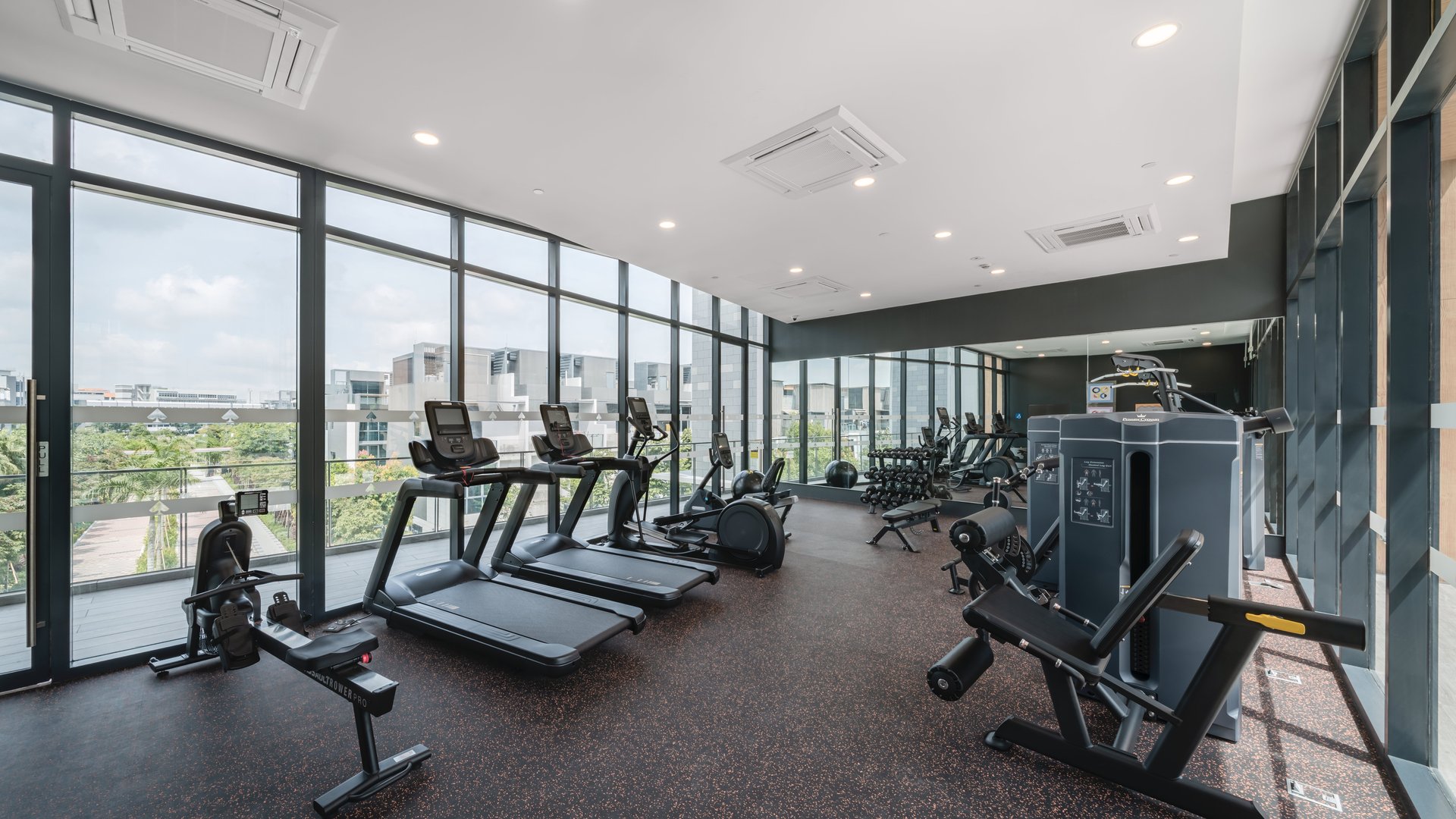 Clubhouse gym with treadmills and weight machines behind full-height glass at Belgravia Ace