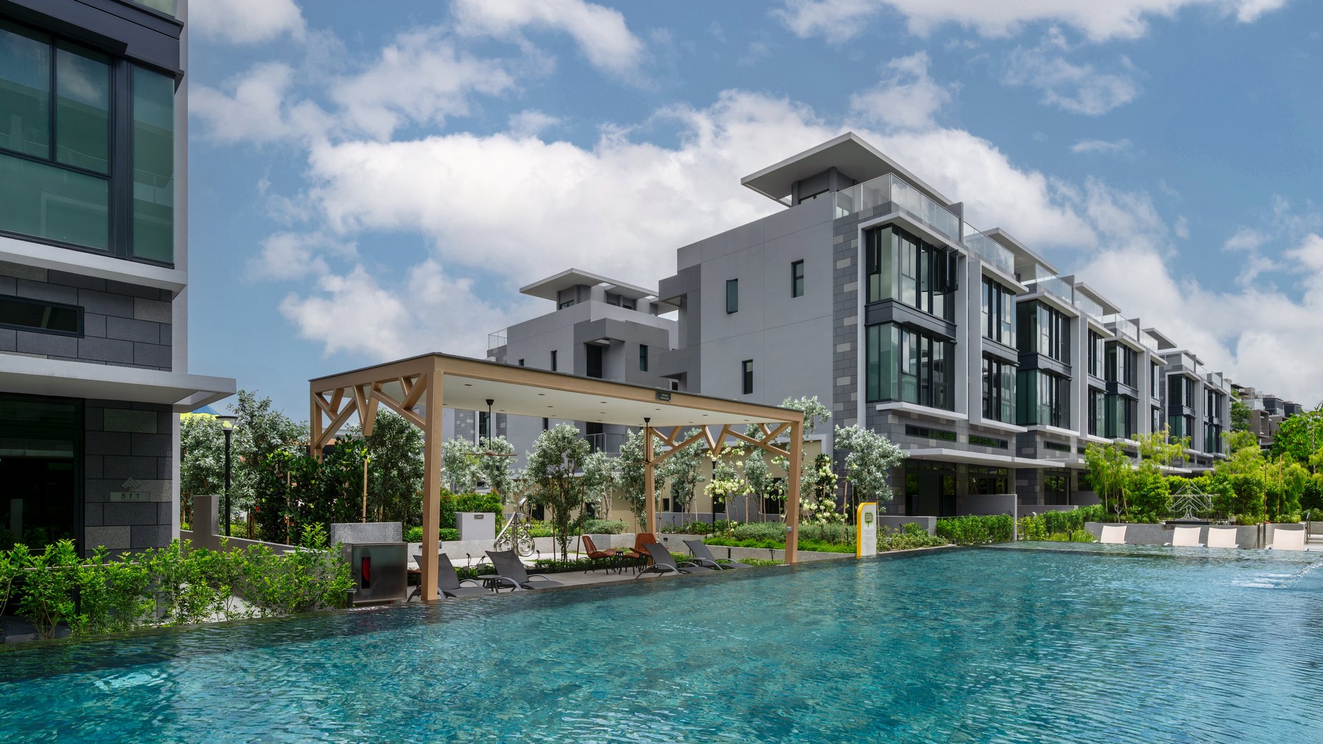 Poolside cabana with loungers beside the lap pool and three-storey semi-detached houses at Belgravia Ace
